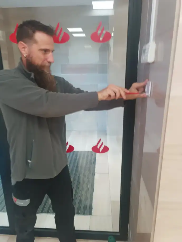 Trabajador de Aingenia instalando alarma en Banco Santander